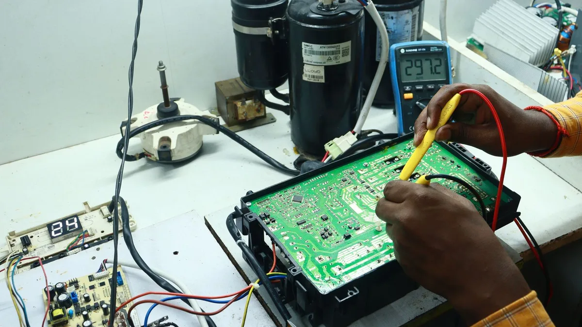 Technik sprawdzający miernikiem płytkę elektroniki sterującej