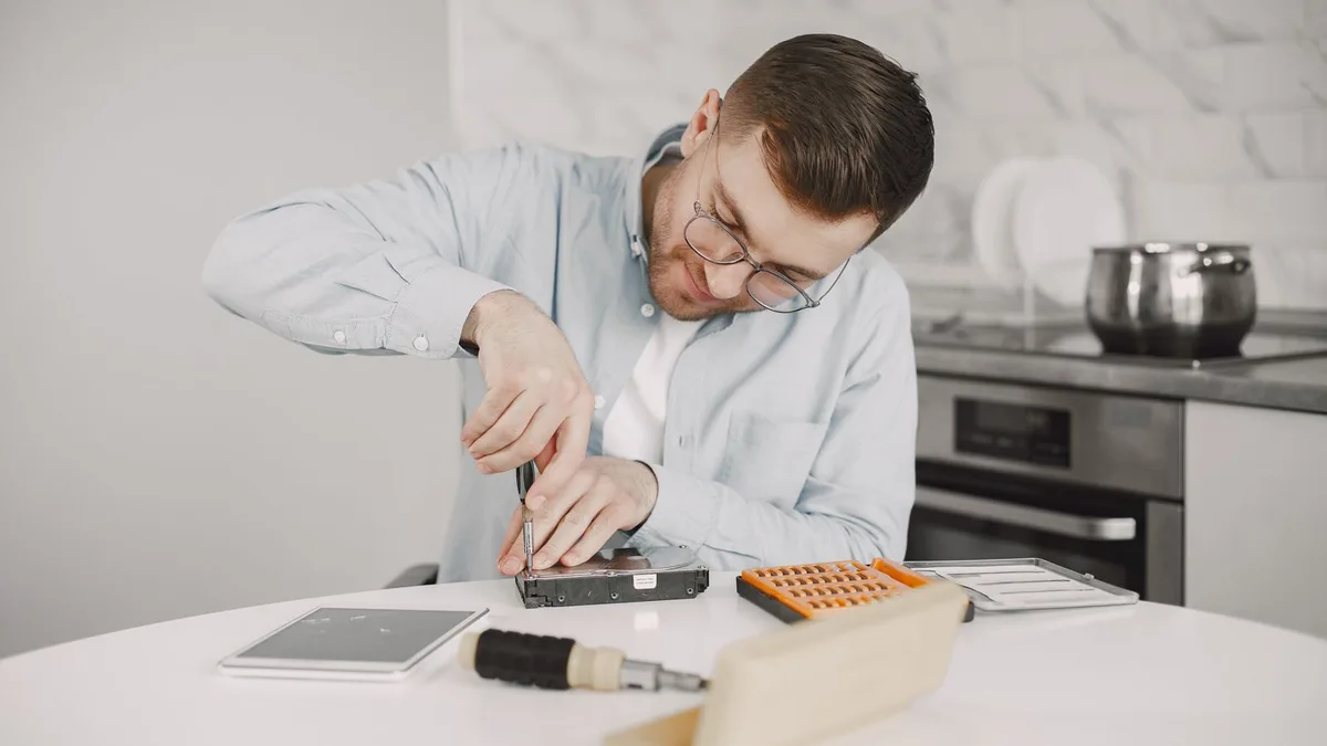 Technik pracujący przy urządzeniu na warsztatowym stole
