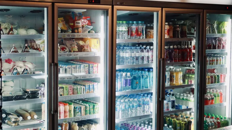 Wnętrze lodówki wypełnione napojami i produktami ustawionymi na kilku półkach